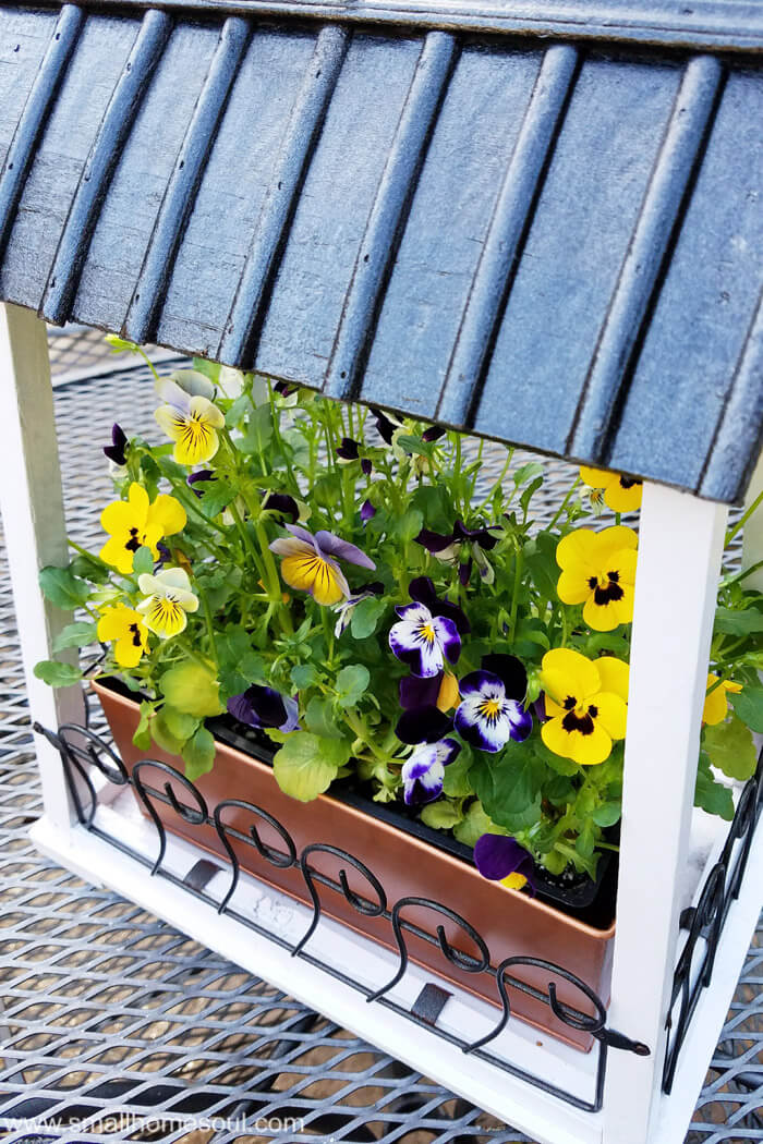 The roof of the hanging flower pot looks like a raised seam roof all painted in metallic.