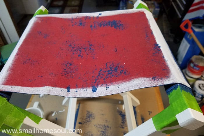 Painting the folding stool seat with blue paint.