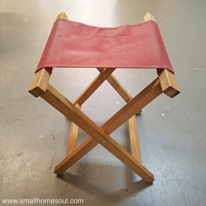 Folding stool with red seat ready for a makeover.