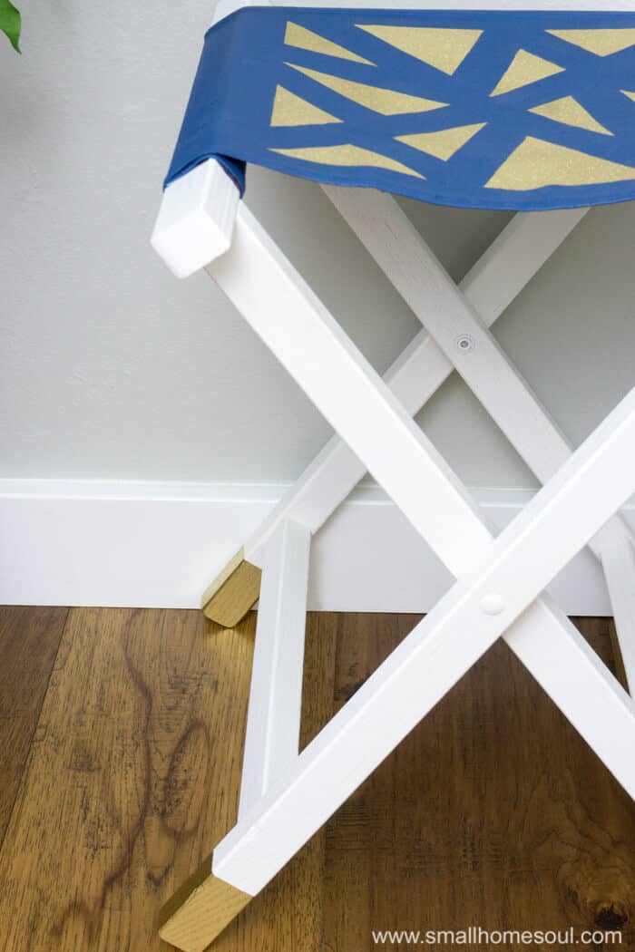 Closeup of gold feet on the folding stool.