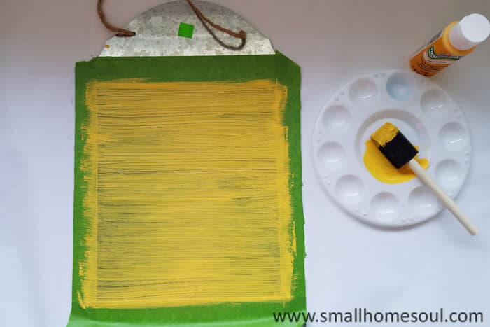 Painting the magnetic memo board a bright yellow.