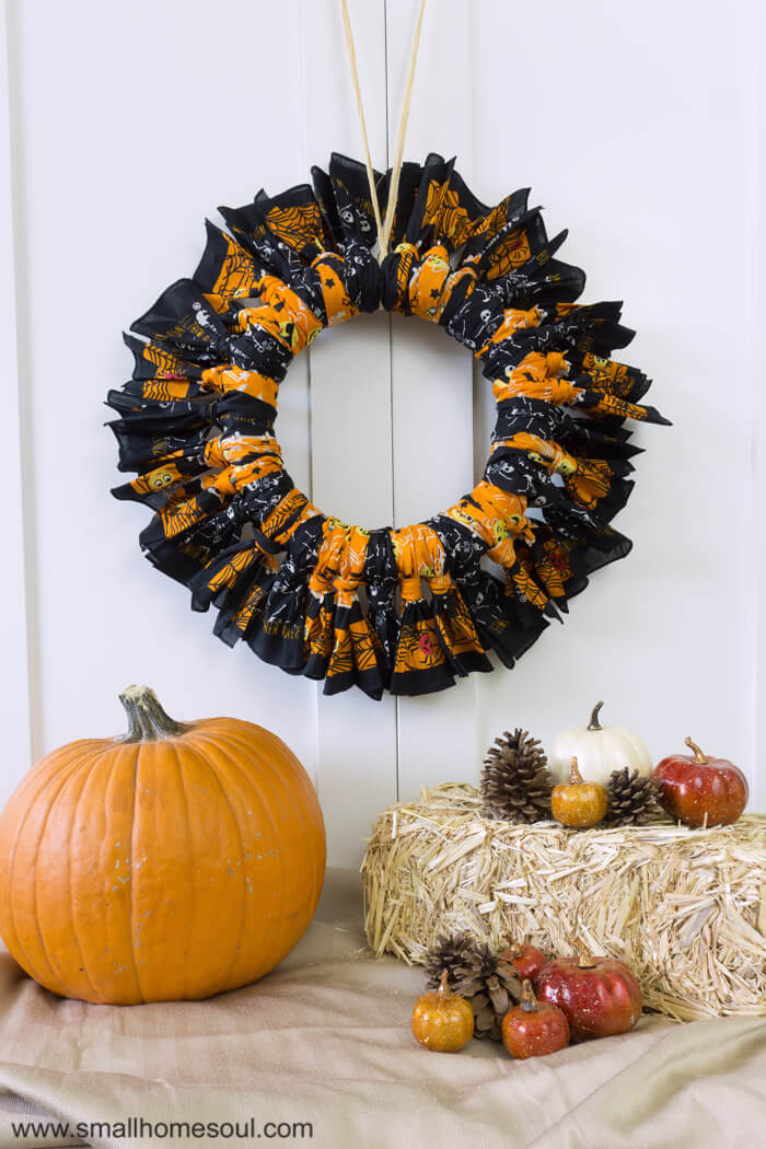 Vignette of halloween bandana wreath with pumpkins and straw.