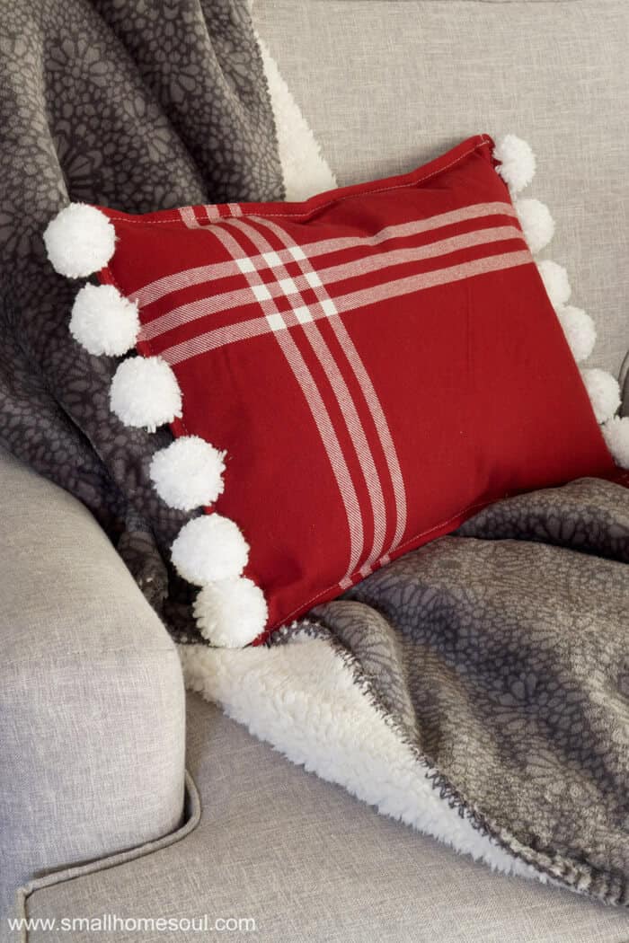 Christmas Pom Pom pillow looking pretty in my chair.
