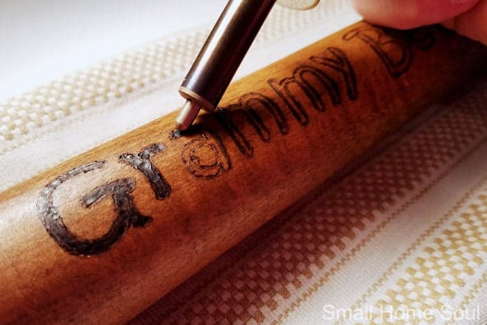Filling in the wood burned areas on the wooden rolling pin.