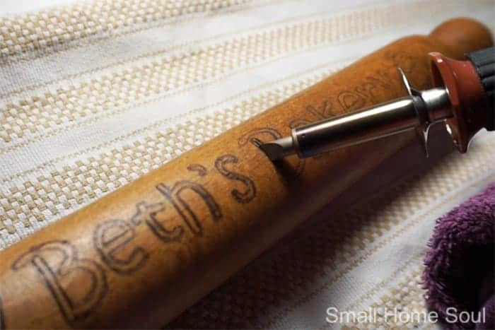 Wood burning a saying onto a wooden rolling pin